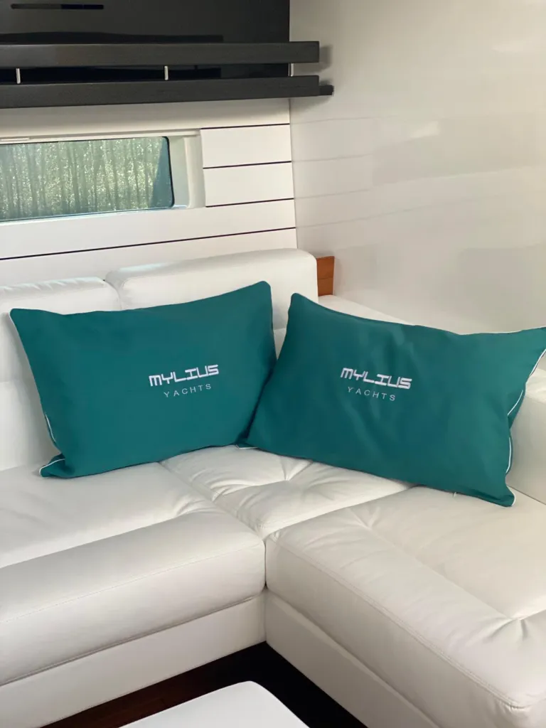 Cuscini con logo del cliente su una seduta bianca dello stand